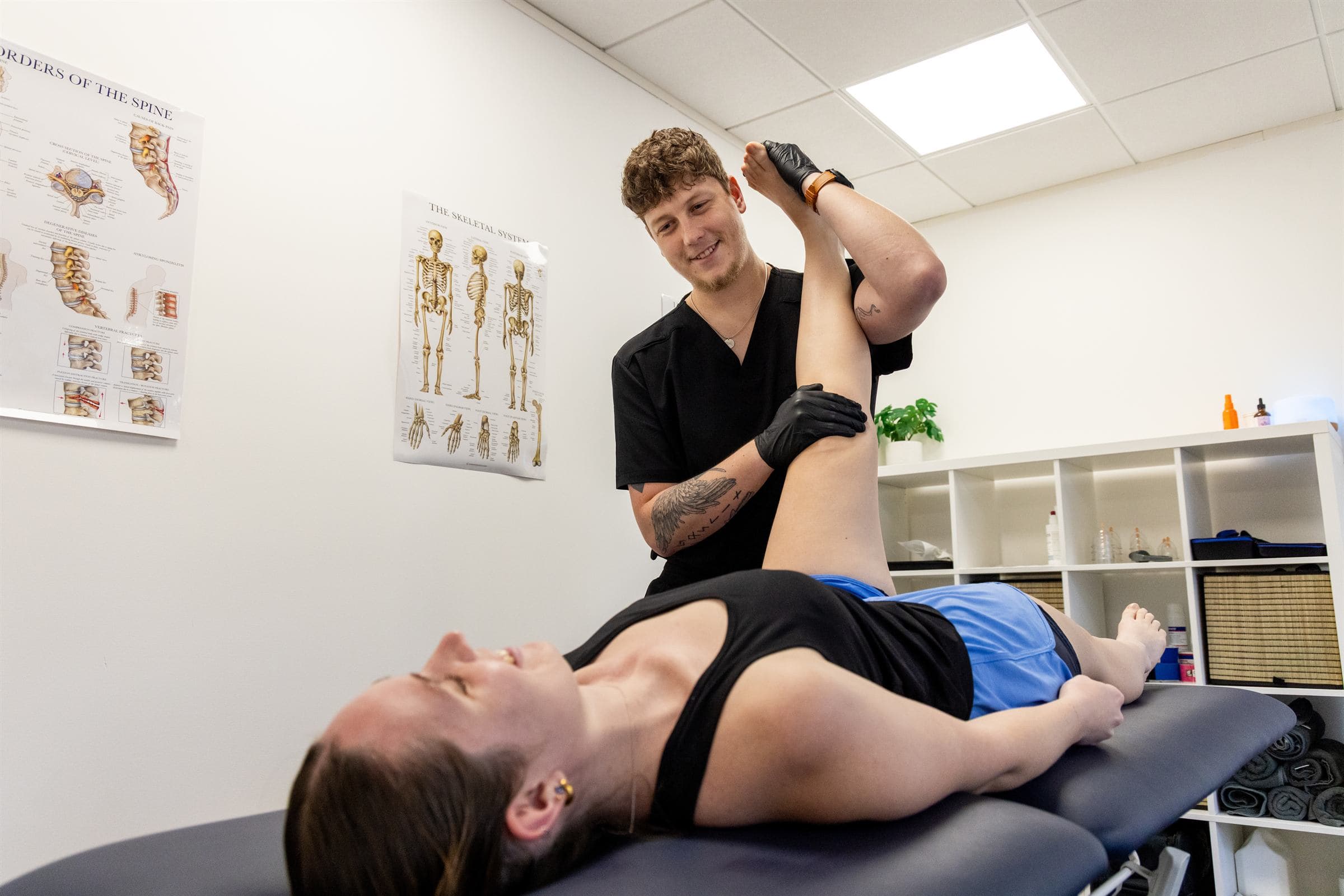 Physiotherapist moving a patient's leg on a treatment couch at Joint Initiative Physiotherapy, Norwich