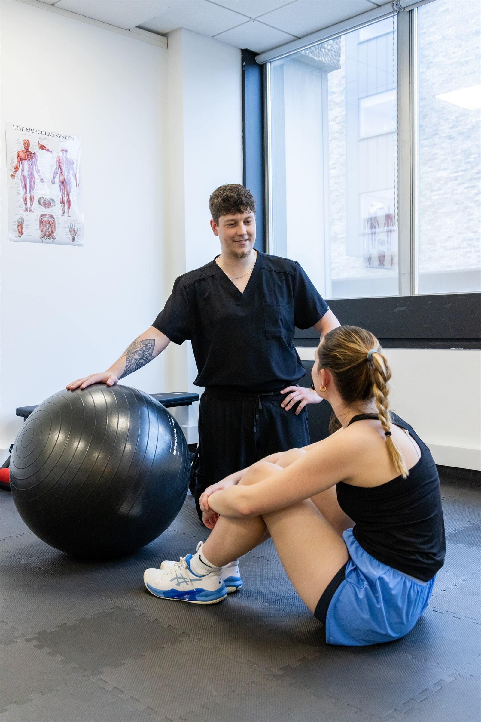 Physiotherapist talking with a patient in the rehab area at Joint Initiative Physiotherapy in Norwich
